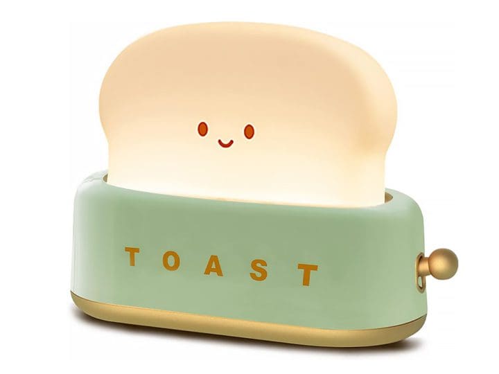 The QANYI Smiling Bread Toaster Light is a delightful and charming lamp featuring a smiling bread sitting in a toaster.